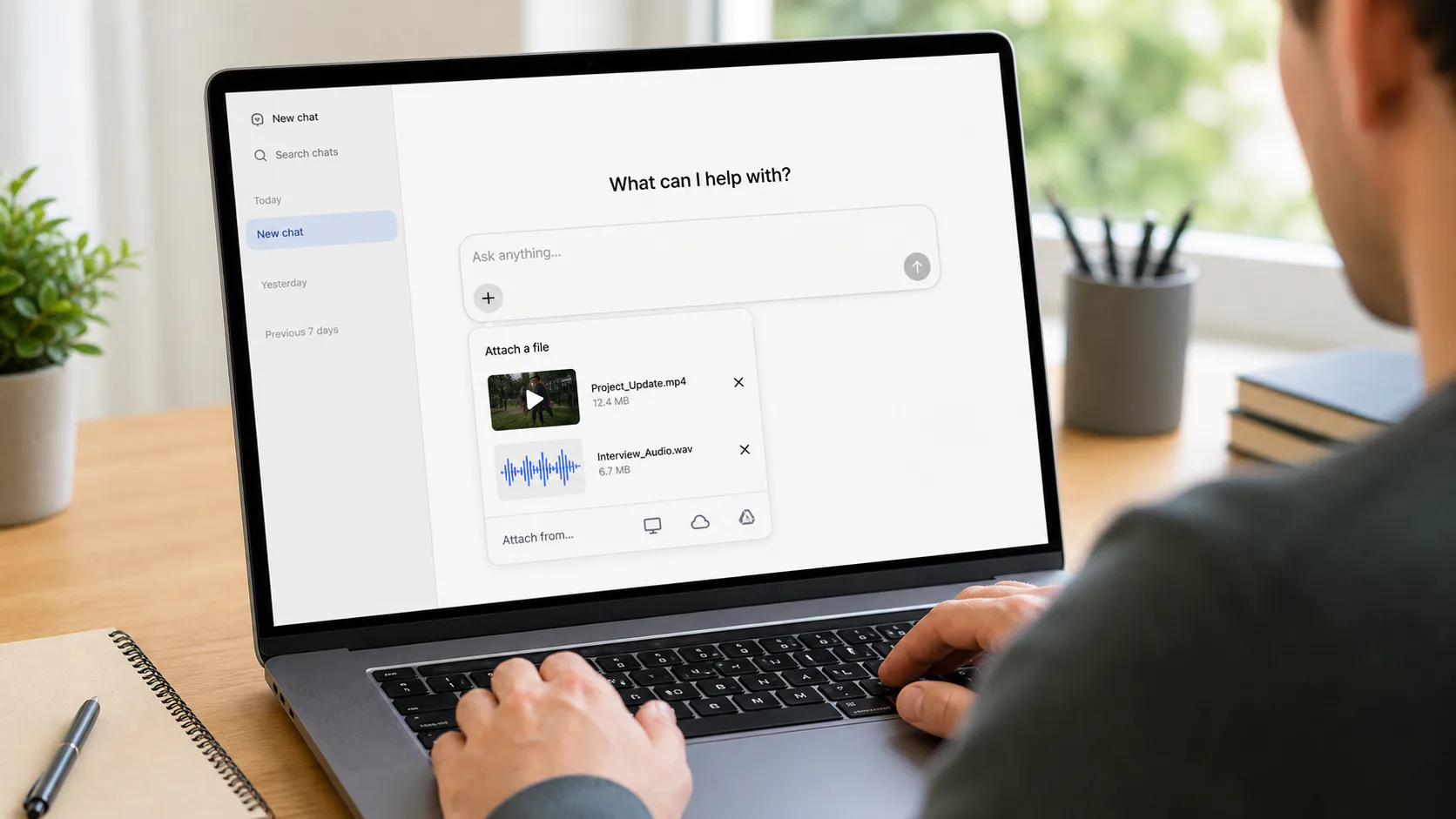 Person attaching a saved video and audio file to a generic AI chat on a laptop